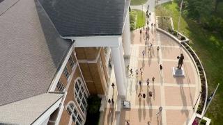 Aerial view of students near campus library with large sidewalks and statue of Abraham Lincoln
